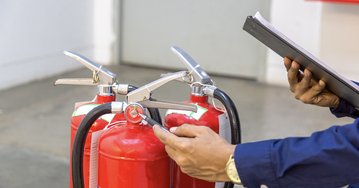 A fire risk assessor services a fire extinsguisher as part of a fire extinguisher service in the uk 