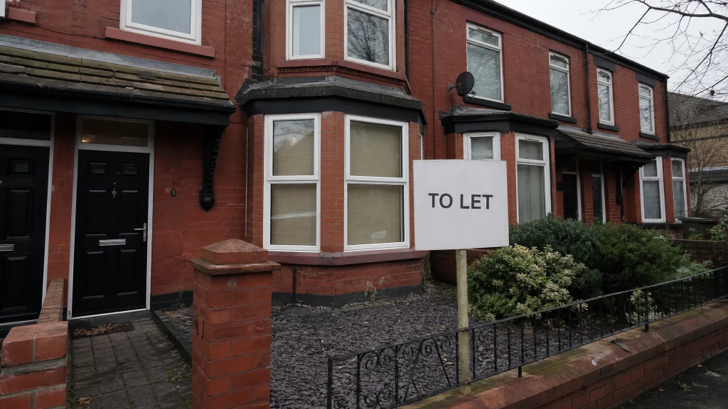 Red brick Victorian terraced house converted into an HMO on a Manchester street with a plain To Let sign