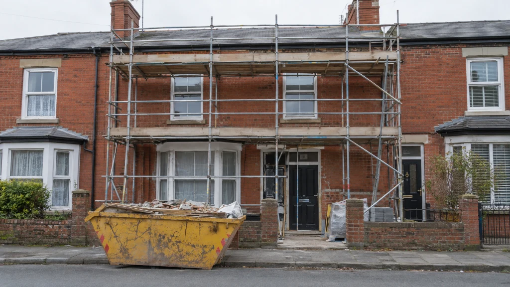 A Victorian red-brick terraced house in Manchester with scaffolding during a renovation